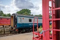 Old style Royal Mail mobile sorting office seen on railway siding, framed by two sleeper cars.