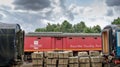 Old style Royal Mail mobile sorting office seen on railway siding, framed by two sleeper cars.