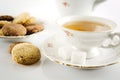 Old-style shot kettle with cup of tea with cookies foreground on Royalty Free Stock Photo