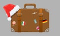 Old style vintage brown voyage suitcase with travel stickers and christmas or santa claus hat or cap. Vector Royalty Free Stock Photo