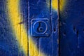 Old-styled front door and metal lock, padlock view. A blue and yellow weathered rusty wooden painted gates. Wooden slats Royalty Free Stock Photo