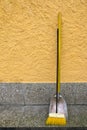 An old styled yellow broom and metal dustpan