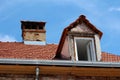 Old suburban family house under reconstruction with new roof window and roof tiles already installed surrounded with shiny gutter Royalty Free Stock Photo