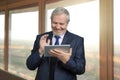 Old successful happy businessman with tablet. Royalty Free Stock Photo