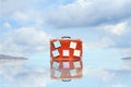 Old suitcase with empty stickers, with reflection, against blue sky with beautiful clouds. Copy space. Travel concept