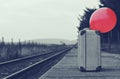 Old suitcase with a red balloon at the train station with retro effect Royalty Free Stock Photo