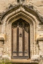 A tall old wooden door with a knocker in the middle of it Royalty Free Stock Photo