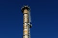 Old tall metal industrial chimney stack with rust spots and ladder Royalty Free Stock Photo