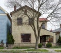 Old Tan Stucco House with Bare Spring Tree