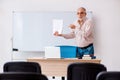 Old male teacher in the classroom in pandemic concept Royalty Free Stock Photo