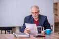 Old teacher physicist sitting in the classroom