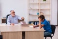 Old male teacher and schoolboy in the classroom