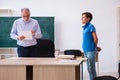 Old male teacher and schoolboy in the classroom