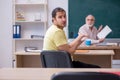 Old teacher and young male student in the classroom Royalty Free Stock Photo