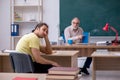 Old teacher and young male student in the classroom Royalty Free Stock Photo