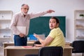 Old teacher and young male student in the classroom Royalty Free Stock Photo