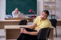 Old teacher and young male student in the classroom Royalty Free Stock Photo