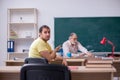 Old teacher and young male student in the classroom Royalty Free Stock Photo
