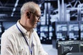 Old technician coding in data center
