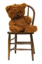 Old teddy bear on antique child's bentwood chair. Royalty Free Stock Photo