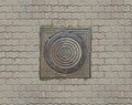 Old teel sewer manhole on the cobblestone road pavement Royalty Free Stock Photo