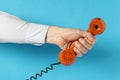 Old telephone receiver in hand over blue background Royalty Free Stock Photo