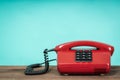 Old telephone on wooden table in front of green background. Vintage phone Royalty Free Stock Photo