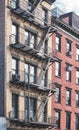 Old tenement house building with fire escape, color toned picture, New York City, USA