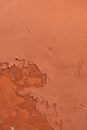 Old terracotta painted stucco wall with chipped paint. Background texture Royalty Free Stock Photo