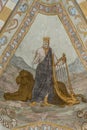 The old testament king david stands in front of a lion and holds the harp, an ancient fresco