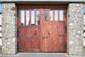 Old textured large hardwood doors, old brick wall with big vintage stable gates mates with forging with forged fitting Royalty Free Stock Photo