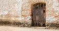 Old textured wooden door on the facade of a town house in Spain.