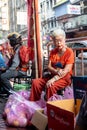 Old Thai Chinese lady selling pears for Chinese New Year along Yaowarat Road Bangkok
