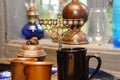 Old things are on the table and the window sill - old cups, copper Jewish menorah, old lamp on kerosene Royalty Free Stock Photo