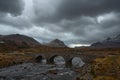 Old three arched stone bridge over the River Sligachan in Isle of Skye Scotland with Cuillin mountain range in the distance, Isle Royalty Free Stock Photo