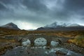 Old three arched stone bridge over the River Sligachan in Isle of Skye Scotland with Cuillin mountain range in the distance, Isle Royalty Free Stock Photo