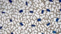 Old tiles in concrete, mosaic, broken ceramics in the building. Background of a house in the city.