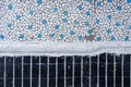 Old tiles in concrete, mosaic, broken ceramics in the building. Background of a house in the city.