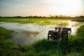 Old tiller or walking tractor in rice field in sunset.