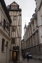 Old and tilted houses at Rue Eau de Robec in Rouen on a rainy day. Rue Eau-de-Robec is one of the main tourist streets