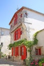 Old timbered red house with shutters and other historical buildings in Ile de Re, Charente Maritime, France Royalty Free Stock Photo