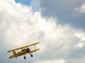 Old yellow biplane aircraft on sunny cloudy sky. Royalty Free Stock Photo