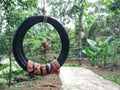 An old tire used as a swing for children to play with.
