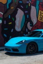 From old to new, Porsche sports cars parked near an art mural in a downtown art Miami district