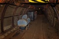 Old toilet wagon and metal mine train in mine tunnel with wooden timbering