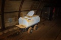 Old toilet wagon and metal mine train in mine tunnel with wooden timbering