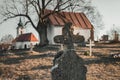 Old Tombstones in public cemetery in European village with chapel on background on sunset. Blank tombstone and graves in ancient