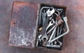 Old toolbox of dirty hand tools on rusty metal table