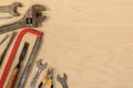 Old tools on a light wooden background, top view