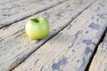 Old torn paint on the boards and a green apple in the foreground Royalty Free Stock Photo